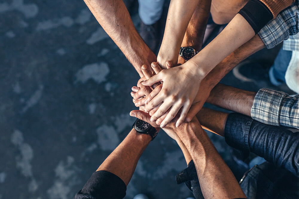 team of people with hands in to show teamwork