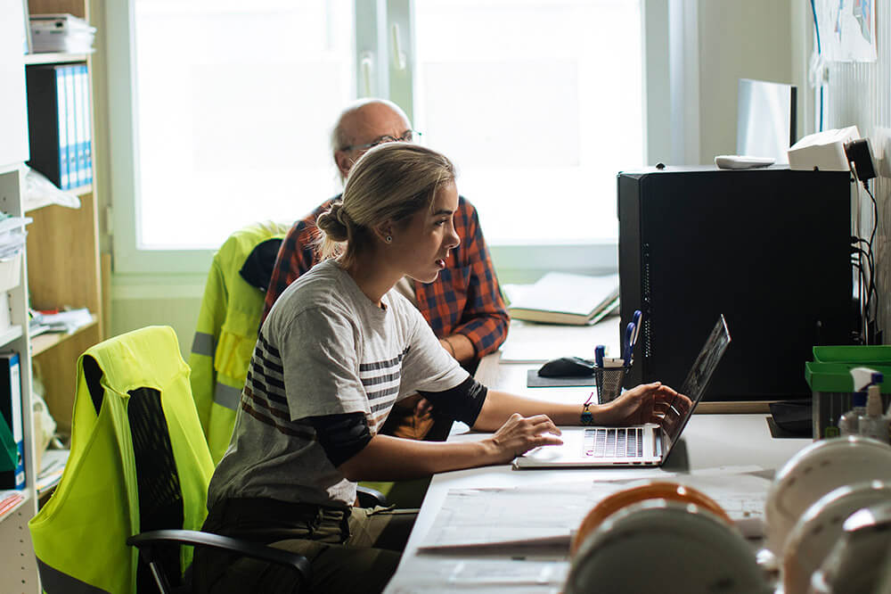 woman in back office working on a computer